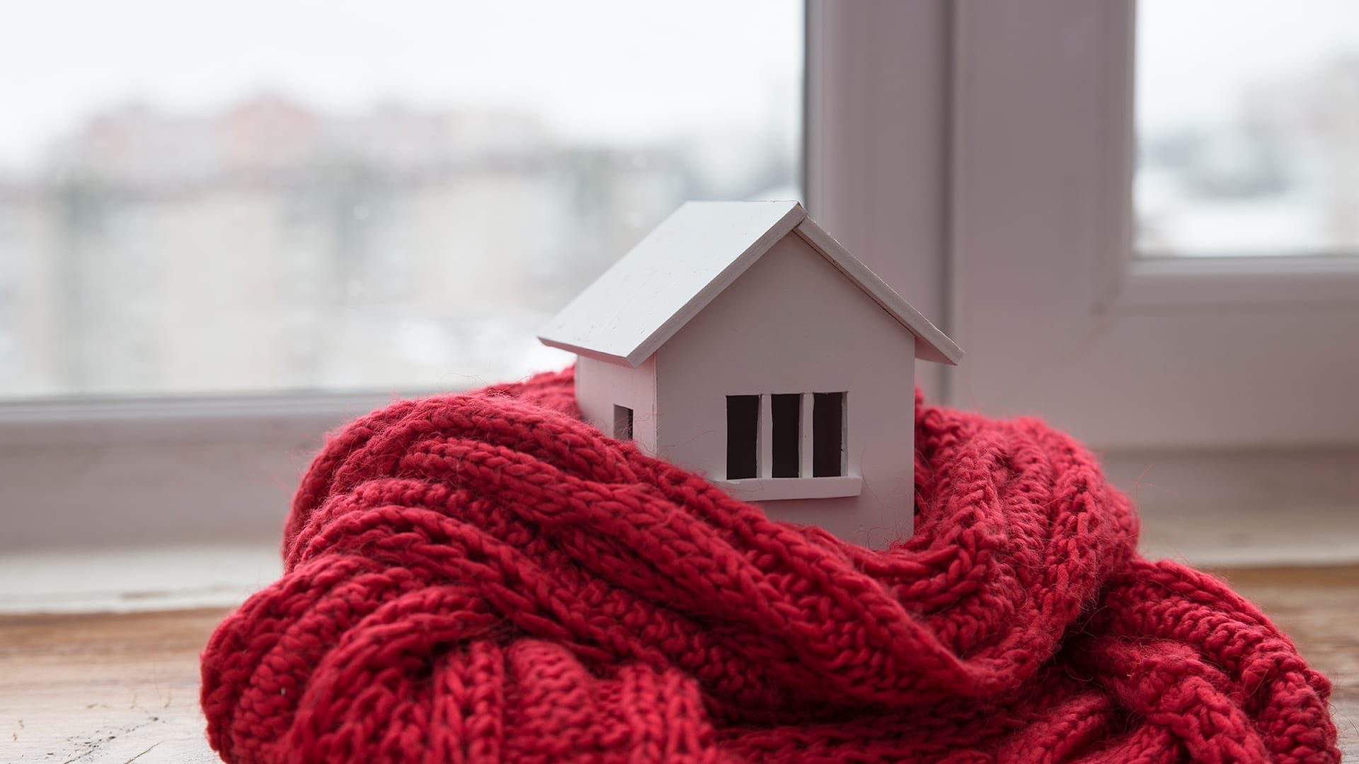 Model of a house wearing a knitted scarf